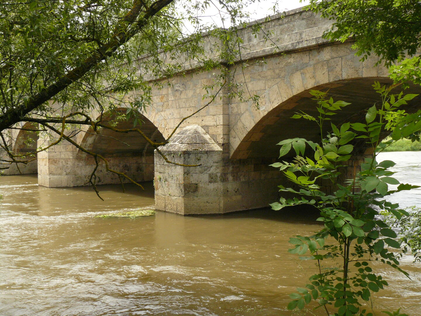 Die Brücke wurde nach dem Krieg wieder aufgebaut. Die Donau hat aufgrund des Regens immer noch Hochwasser (nein, nicht der Fluß Regen, der fließt erst bei Regensburg rein).
