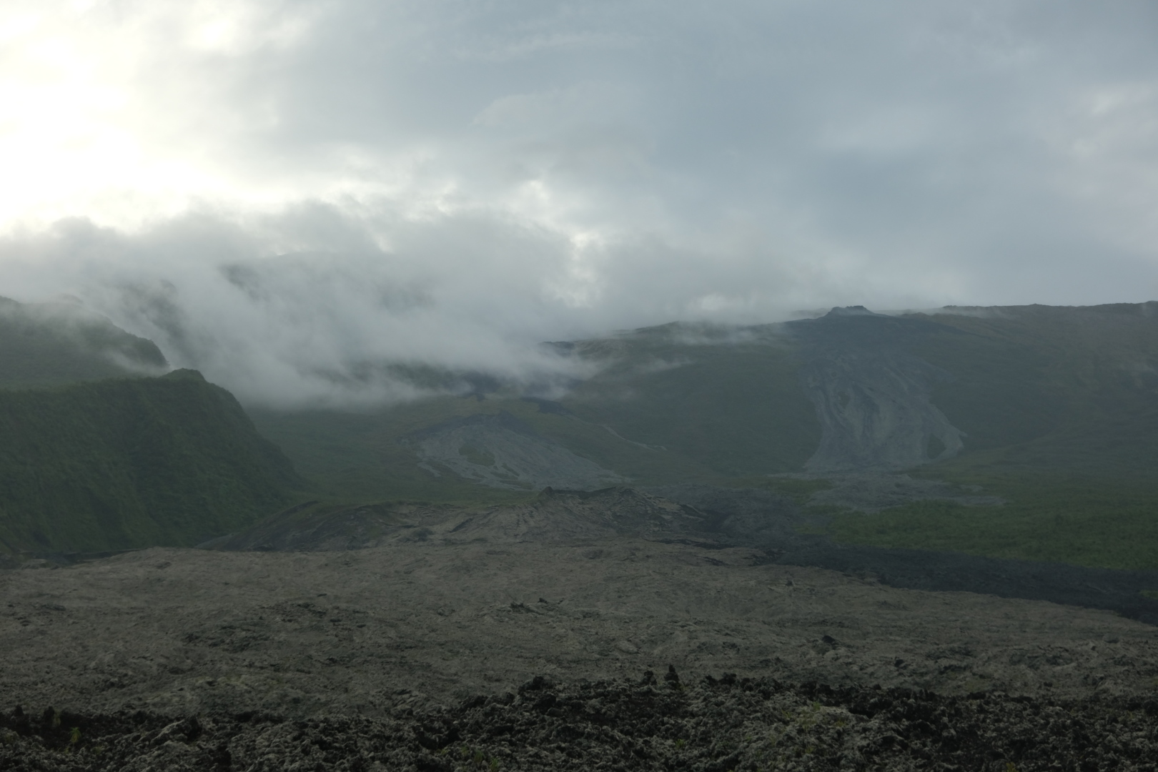 In der Grand Brûlé. Vom Piton de la Fournaise im Westen, dessen Gipfel in den Wolken liegt, fließen immer wieder Lavaströme herab. Dieser hier ist von 2004. Außer Flechten wächst auf der knapp 20 Jahre alten Lava noch nicht viel.
